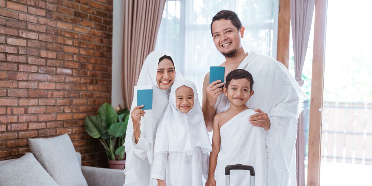 Smiling Muslim family in ihram clothing holding passports and preparing for Hajj pilgrimage at home