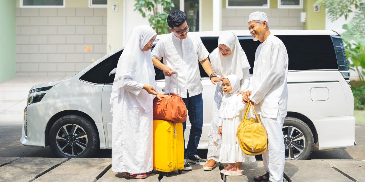 A Muslim family dressed in white stands by a white van with their luggage, preparing for their sacred pilgrimage