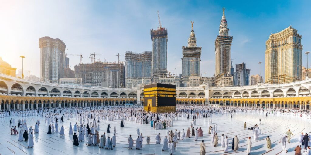 Wide shot of the Kaaba in Mecca surrounded by many pilgrims in white ihram under a bright, clear blue morning sky